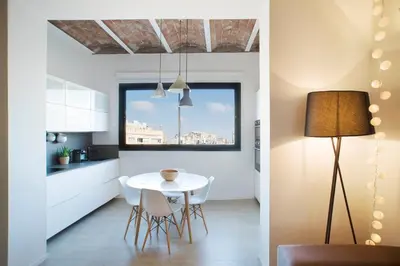 a kitchen and dining room with a white table and chairs at Barcelona InLoft in Barcelona
