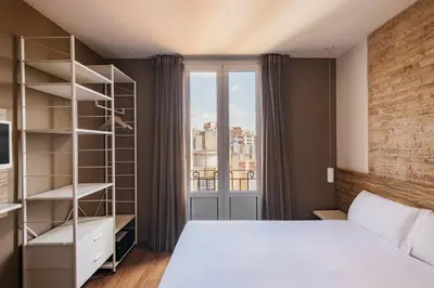 a bedroom with a white bed and a window at Barcelona Apartment Milà in Barcelona