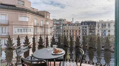 a table with a plate of food on a balcony at Stay U-nique Apartment Tamarit in Barcelona