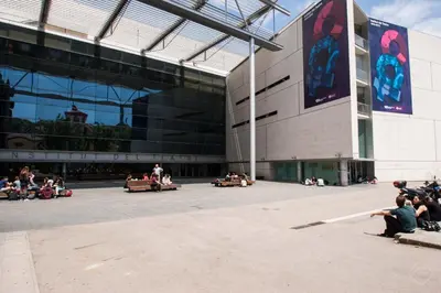 people riding in bumper cars in front of a building at Rustic Poble Sec Apartment in Barcelona