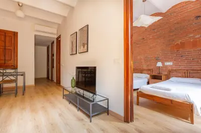 a bedroom with a bed and a brick wall at Eixample Sagrada Familia Apartments II in Barcelona