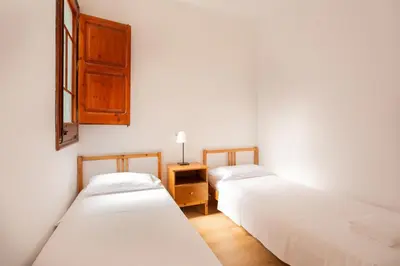 two beds in a room with white walls at Eixample Sagrada Familia Apartments II in Barcelona