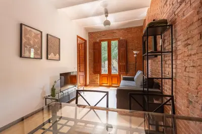 a staircase in a living room with a brick wall at Eixample Sagrada Familia Apartments II in Barcelona