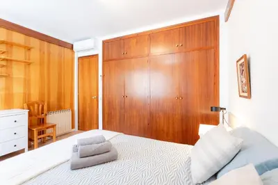 a bedroom with a bed and a wooden wall at Secrets of Montserrat in El Bruc