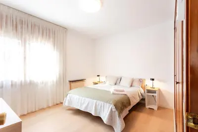 a white bedroom with a bed and a window at Secrets of Montserrat in El Bruc