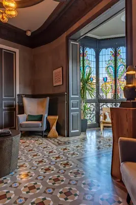 a lobby with a chair and a stained glass window at SuiteaBCN in Barcelona