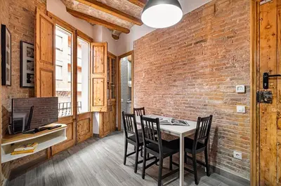 a dining room with a brick wall and a table and chairs at Stay U-nique Apartment Ermengarda in Barcelona