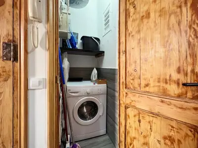 a washing machine in a small room with a door at Stay U-nique Apartment Ermengarda in Barcelona