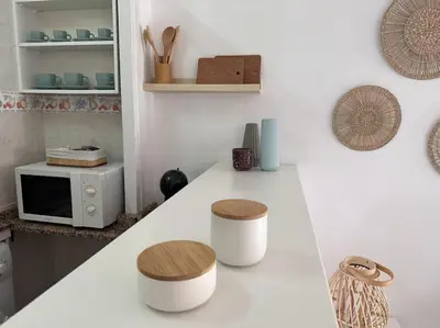 a kitchen with a counter with two stools and a microwave at Preciosas vistas al mar en Castelldefels in Castelldefels