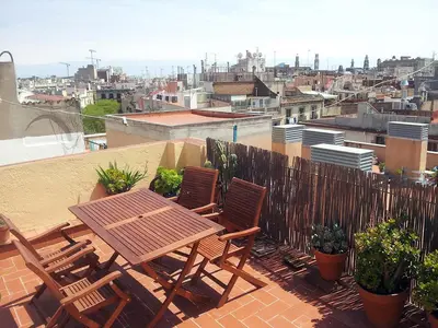 a wooden table and chairs sitting on a roof at The Panoramic View Born Penthouse in Barcelona