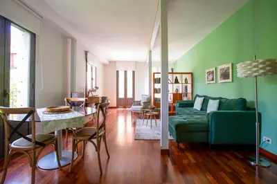 a living room with a green couch and a table at The Luxury Open Space MACBA loft in Barcelona