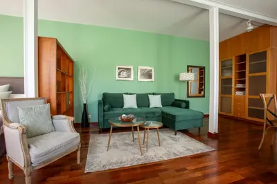 a living room with a green couch and a table at The Luxury Open Space MACBA loft in Barcelona
