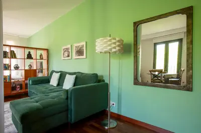a living room with a green couch and a mirror at The Luxury Open Space MACBA loft in Barcelona
