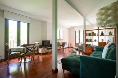 a living room with a green couch and a table at The Luxury Open Space MACBA loft in Barcelona