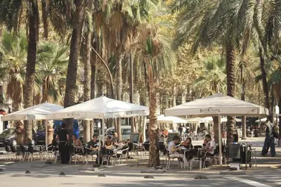 a group of people sitting in chairs under umbrellas at The Luxury Open Space MACBA loft in Barcelona