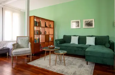 a living room with a green couch and a table at The Luxury Open Space MACBA loft in Barcelona