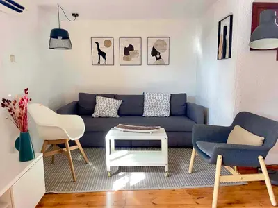 a living room with a blue couch and two chairs at Barcelona Old Town attic near Catalunya square in Barcelona