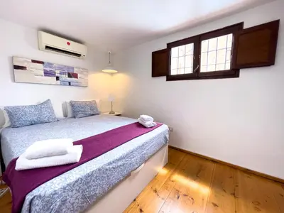 a bedroom with a bed and two windows at Barcelona Old Town attic near Catalunya square in Barcelona