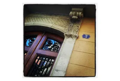 a building with a wooden door and a pillar at Barcelona Old Town attic near Catalunya square in Barcelona
