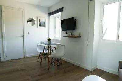 a living room with a table and chairs and a television at Apartament Roca Foradada in Monistrol