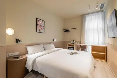 a hotel room with a large white bed and a window at La Florida Suites by Olala Homes in Hospitalet de Llobregat
