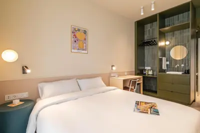 a bedroom with a large white bed and a bathroom at La Florida Suites by Olala Homes in Hospitalet de Llobregat