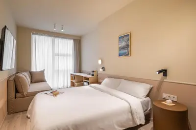 a hotel room with a large bed and a chair at La Florida Suites by Olala Homes in Hospitalet de Llobregat