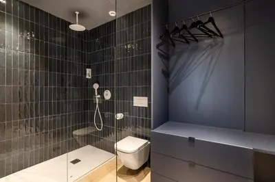 a bathroom with a toilet and a glass shower at La Florida Suites by Olala Homes in Hospitalet de Llobregat