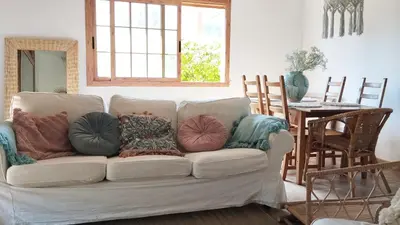 a living room with a white couch with pillows on it at AMIRA home near Sitges in Sant Pere de Ribes