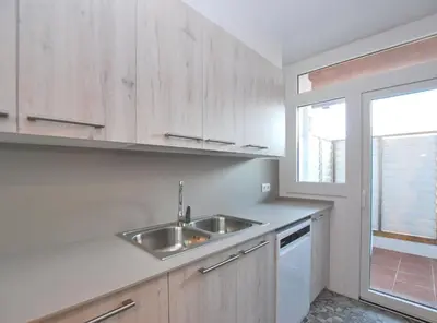 a white kitchen with a sink and a window at Santa Maria apartment in Vilassar de Mar