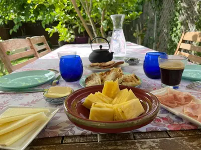 a table with a plate of food and a bowl of fruit at Lemon Tree GuestHouse in Tiana