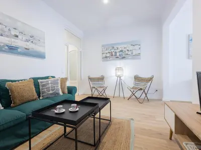 a living room with a green couch and a table at Matarolux24 in Mataró