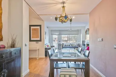 a dining room and living room with a table and chairs at Luxury Muntaner Plaza in Barcelona