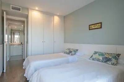 two beds in a room with white walls at Luxury Muntaner Plaza in Barcelona