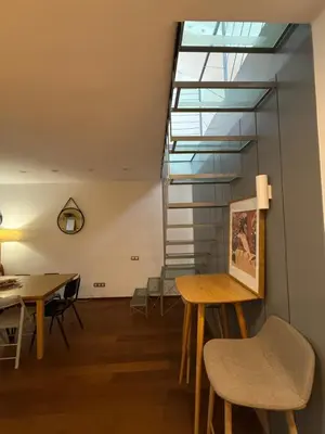a room with a table and chairs and a staircase at Maravilloso piso en el corazón de Barcelona in Barcelona