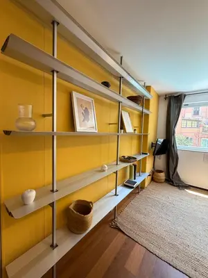 a room with shelves and a yellow wall at Maravilloso piso en el corazón de Barcelona in Barcelona