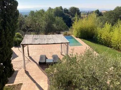 a gazebo with two chairs and a swimming pool at Habitación suite en Masía Can Robira in Els Hostalets