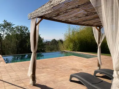 a pavilion with two chairs and a swimming pool at Habitación suite en Masía Can Robira in Els Hostalets