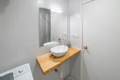 a bathroom with a white sink and a mirror at Welcomy Sant Andreu in Barcelona