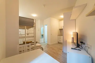 a kitchen and living room with a bunk bed at Welcomy Sant Andreu in Barcelona