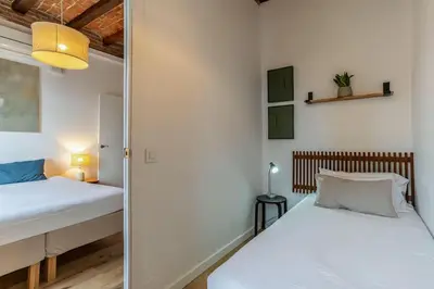 two beds in a small room with white walls at Canela Homes BARCELONA CÒRSEGA in Barcelona