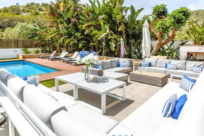 a patio with white couches and a table and a pool at Tranquil large 6 bedroom family Villa sleeps 20 near sitges in Sant Pere de Ribes