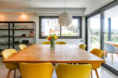 a dining room with a wooden table and yellow chairs at Tranquil large 6 bedroom family Villa sleeps 20 near sitges in Sant Pere de Ribes