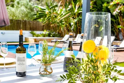 a table with bottles of wine and glasses on it at Tranquil large 6 bedroom family Villa sleeps 20 near sitges in Sant Pere de Ribes