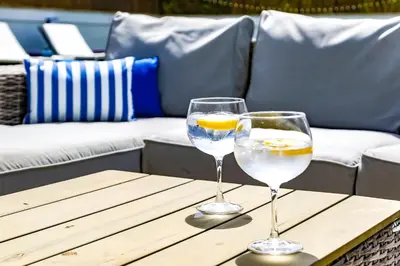 two wine glasses sitting on a wooden table at Tranquil large 6 bedroom family Villa sleeps 20 near sitges in Sant Pere de Ribes
