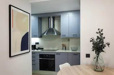 a kitchen with blue cabinets and a wooden table at Cozy Apartment Les Corts in Barcelona