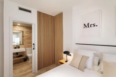 a bedroom with a king sized bed and a bathroom at Cozy Apartment Les Corts in Barcelona