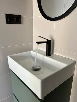 a white sink with a faucet in a bathroom at Crysoyle Apartment Barcelona Next to Camp Nou in Hospitalet de Llobregat