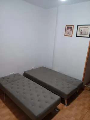 a bed sitting in a room next to a wall at Casa Ferrer Barcelona in Hospitalet de Llobregat