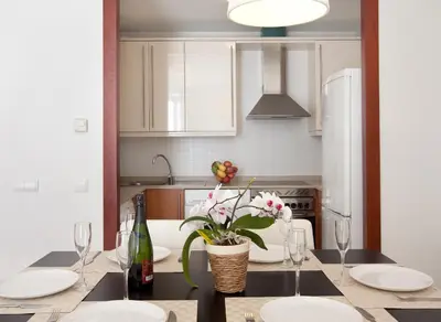 a kitchen with a table with glasses and flowers on it at Blaumar in Sitges